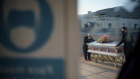 Imagen referencial. Personal de una funeraria lleva un ataúd a un vehículo fúnebre en Estados Unidos, 4 de diciembre de 2020. (Foto: Paul Ratje / AFP).