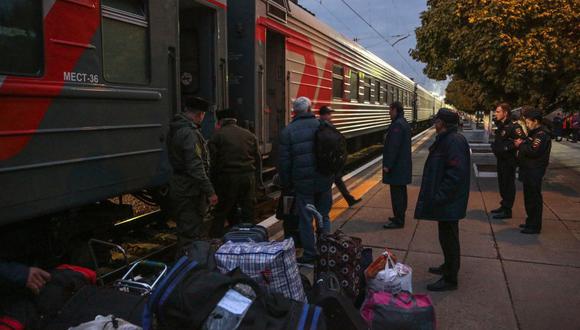 Las personas que llegaron de Kherson cargan sus pertenencias en un vagón para una mayor evacuación a las profundidades de Rusia en la estación de tren de Dzhankoi en Crimea el 21 de octubre de 2022. (Foto de STRINGER / AFP)