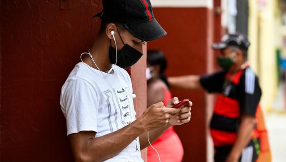 Un joven usa su teléfono en una calle de La Habana (Cuba), el 14 de julio de 2021. (YAMIL LAGE / AFP).