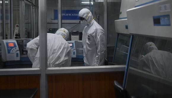 Los técnicos que usan trajes de equipo de protección personal se ven dentro de una instalación de laboratorio molecular  en el Instituto King en Chennai el 28 de julio de 2022. (Foto referencial: Arun SANKAR / AFP)