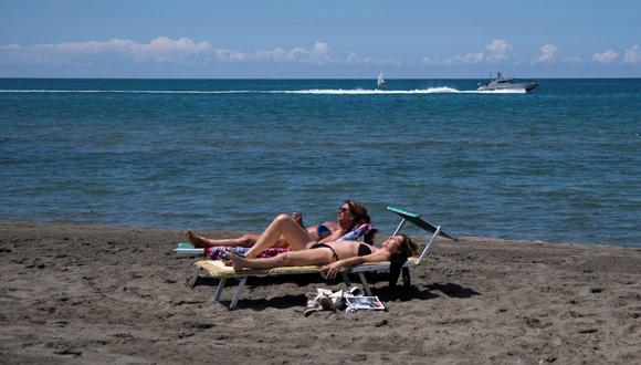 La gente toma sol en una playa en Fregene, cerca de Roma, Italia. (AFP / Tiziana FABI).