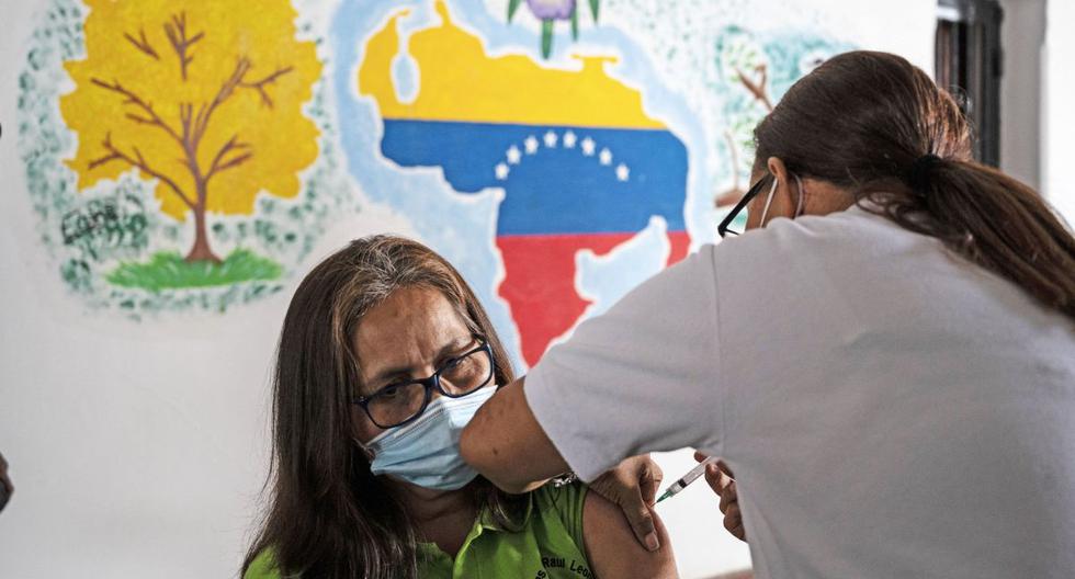 Una docente recibe una dosis de la vacuna COVID-19 desarrollada por Sinopharm en un centro de vacunación en la escuela secundaria Miguel Antonio Caro en Catia, Venezuela, el 8 de marzo de 2021. (Yuri CORTEZ / AFP).