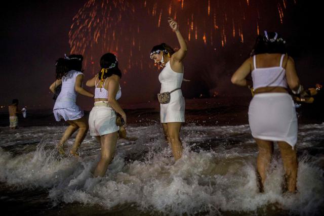 En esta imagen se puede observar una de las tradiciones más comunes en esta fiesta de fin de año, saltar 7 olas. (AFP)