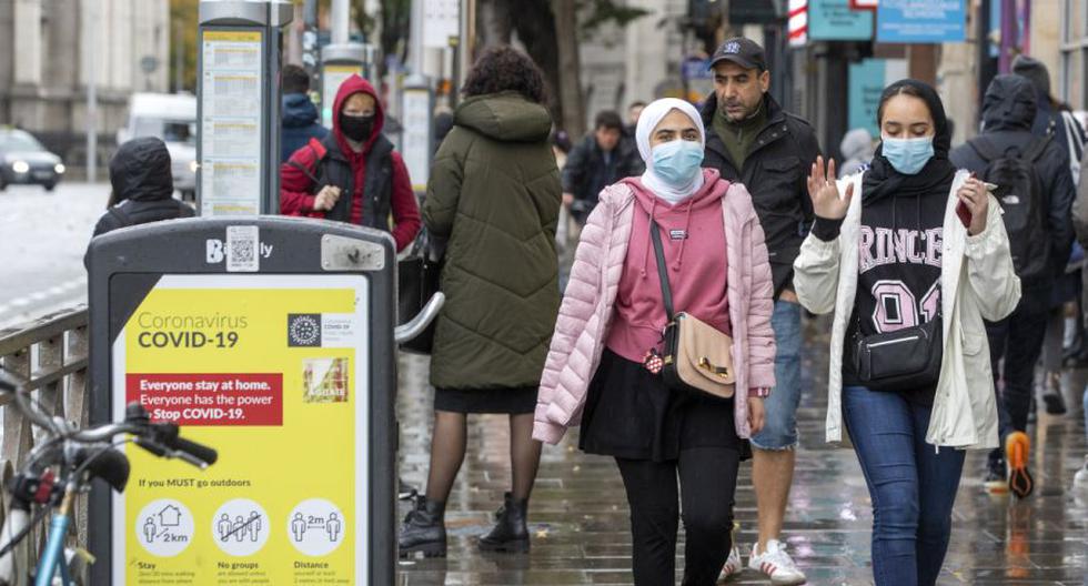 Imagen referencial. Las personas con cubiertas faciales por el coronavirus caminan en Dublín, Irlanda, el 19 de octubre de 2020. (PAUL FAITH / AFP).