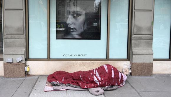Una persona sin hogar duerme frente a una tienda de Victoria's Secret en el Upper West Side de Nueva York el 22 de febrero de 2021. (Foto de TIMOTHY A. CLARY / AFP)