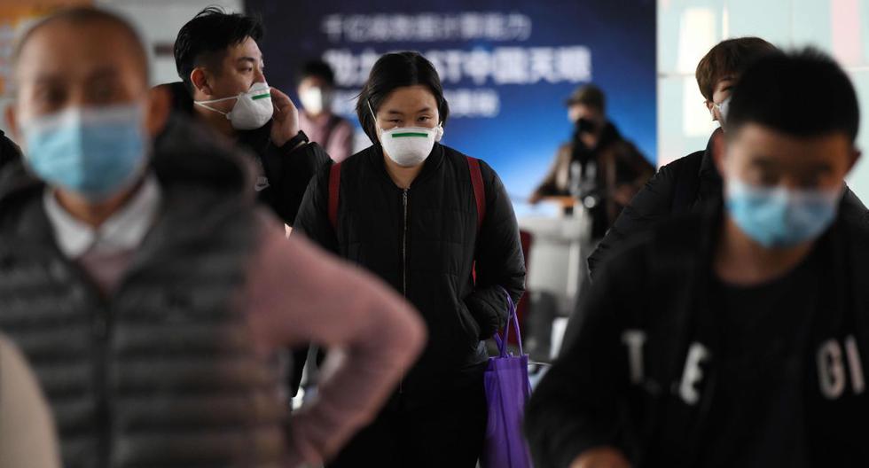 Los pasajeros usan mascarilla como medida preventiva contra el coronavirus cuando llegan de un vuelo en el Aeropuerto de Beijing. (AFP).