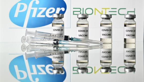 En esta foto de archivo tomada el 17 de noviembre de 2020 muestra viales con adhesivos de la vacuna Covid-19 adheridos y jeringas con el logotipo de la compañía farmacéutica estadounidense Pfizer y el socio alemán BioNTech. (Foto de JUSTIN TALLIS / AFP).