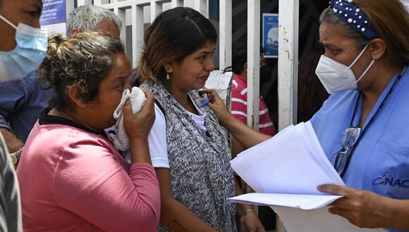 Un médico forense habla con familiares de las víctimas de una estampida después de un concierto por el día de la independencia de Guatemala fuera del Instituto de Ciencias Forenses en Quetzaltenango, 200 km al oeste de la ciudad de Guatemala, el 15 de septiembre de 2022. (Foto por Johan ORDONEZ / AFP)