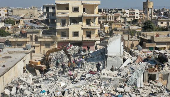 Una vista aérea muestra una excavadora trabajando en los escombros de un edificio derrumbado en la ciudad de Jindayris, controlada por los rebeldes sirios, el 15 de febrero de 2023, luego del terremoto del 6 de febrero que azotó a Turquía y Siria. (Foto de Omar HAJ KADOUR / AFP)