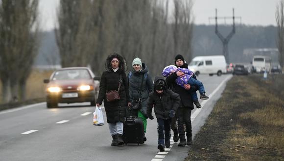 Refugiados de Ucrania caminan por una carretera después de cruzar el puesto de control fronterizo entre Moldavia y Ucrania cerca de la ciudad de Palanca el 1 de marzo de 2022. (Foto de Nikolay DOYCHINOV / AFP)