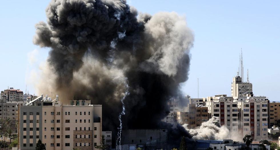 Una espesa columna de humo se eleva desde una torre cuando es destruida en un ataque aéreo israelí en la ciudad de Gaza controlada por el movimiento palestino Hamas, el 15 de mayo de 2021.  (MAHMUD HAMS / AFP).