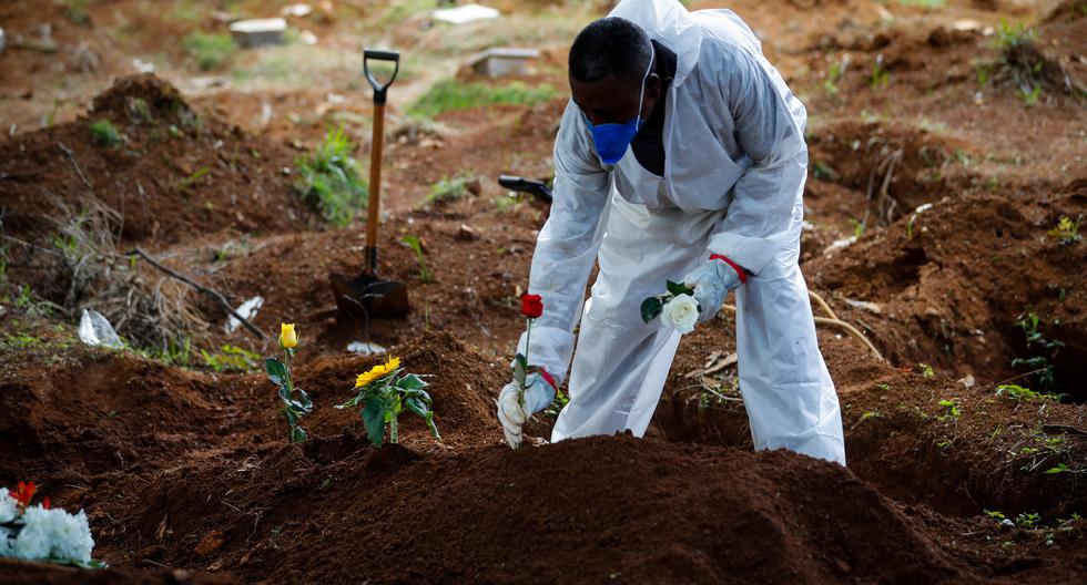 Trabajadores llevan a cabo el entierro de una víctima de COVID-19 en el Cementerio Vila Formosa el 11 de marzo de 2021, en Sao Paulo (Brasil). (EFE/FERNANDO BIZERRA).