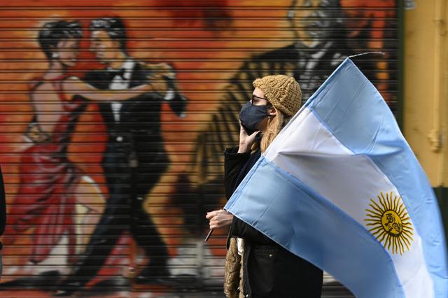 Una mujer camina con la bandera de Argentina en protesta contra el Presidente Alberto Fernández. (Fotos: JUAN MABROMATA / AFP)