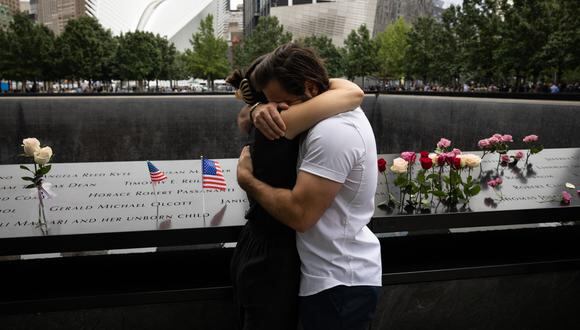 La gente se abraza en el Memorial del 11 de septiembre en la ciudad de Nueva York, el 11 de septiembre de 2022, en el 21 aniversario de los ataques contra el World Trade Center, el Pentágono y Shanksville, Pensilvania. (Foto de Yuki IWAMURA / AFP)