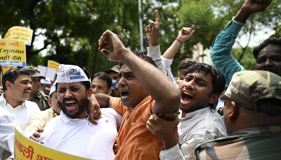Activistas del Partido Aam Aadmi (AAP) de la India gritan consignas cerca de la sede del Partido Bharatiya Janata (BJP) durante una protesta en Nueva Delhi el 27 de julio de 2022, luego de que al menos 30 personas supuestamente murieran debido al consumo de licor falso en el estado de Gujarat. (Foto de Sajjad HUSSAIN / AFP)