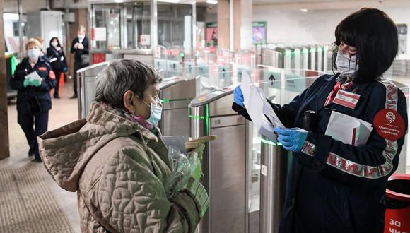 An inspector checks documents of a woman at Savyolovskaya metro station on the first day of mandatory use of masks and gloves on Moscow public transport, in Moscow on May 12, 2020, amid the coronavirus pandemic. (Photo by Kirill KUDRYAVTSEV / AFP)