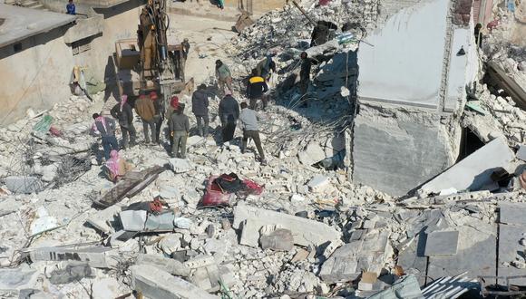 Una vista aérea muestra una excavadora trabajando en los escombros de un edificio derrumbado en la ciudad de Jindayris, controlada por los rebeldes sirios, el 15 de febrero de 2023, luego del terremoto del 6 de febrero que azotó a Turquía y Siria. (Foto de Omar HAJ KADOUR / AFP)