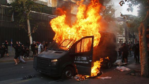 Fotografía de un vehículo de Carabineros en llamas durante una manifestación en la Plaza Italia de Santiago (Chile). (EFE/Sebastián Silva).