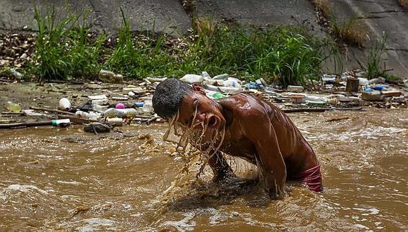 Venezuela: En busca de objetos para vender, jóvenes se zambullen en aguas residuales (FOTOS)
