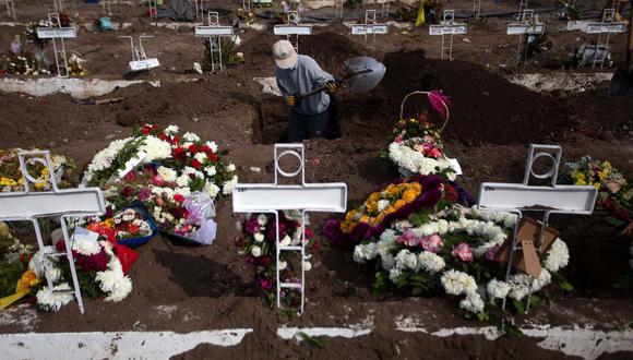 Un hombre trabaja en la sepultura de una personas en el Cementerio General de Santiago, en medio de la pandemia del nuevo coronavirus. (AFP / Claudio REYES)