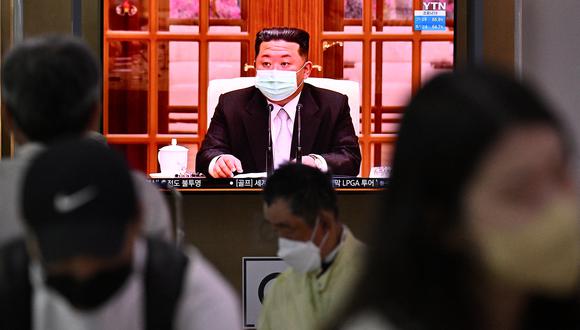 Las personas se sientan cerca de una pantalla que muestra una transmisión de noticias en una estación de tren en Seúl el 12 de mayo de 2022, del líder de Corea del Norte, Kim Jong Un. (Foto: Anthony WALLACE / AFP)