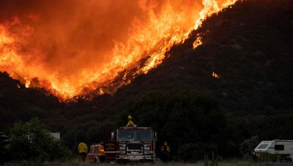 Los bomberos observan cómo las llamas se acercan a una línea retardante cerca de una comunidad residencial, durante el incendio en Cherry Valley. (AFP/JOSH EDELSON)