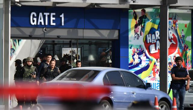 Personal de seguridad en la entrada de "The Terminal 21 mall", donde ayer un joven entró con un arma y mató a 26 personas. Familias de las víctimas mortales y heridas realizaron una vigilia tras la muerte de 26 personas en manos del militar tailandés. (AFP).