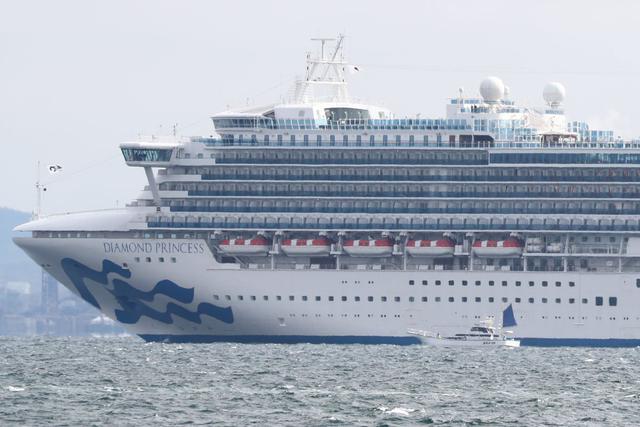 En la imagen se observa un pequeño bote al lado del crucero Diamond Princess con más de 3.000 personas mientras se encuentra anclado en cuarentena frente al puerto de Yokohama. (AFP)