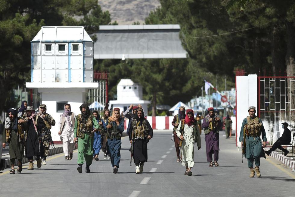 Los combatientes talibanes caminan por la puerta de entrada principal del aeropuerto de Kabul, Afganistán, el 28 de agosto de 2021. (WAKIL KOHSAR / AFP).