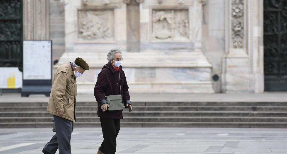 Dos personas caminan en Milán, Italia, durante el confinamiento por el COVID-19. (Foto: MIGUEL MEDINA / AFP)