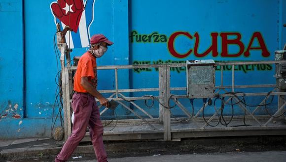 Un anciano con mascarilla pasa junto a un grafiti con la bandera cubana en La Habana, el 11 de agosto de 2021. (Foto: YAMIL LAGE / AFP)