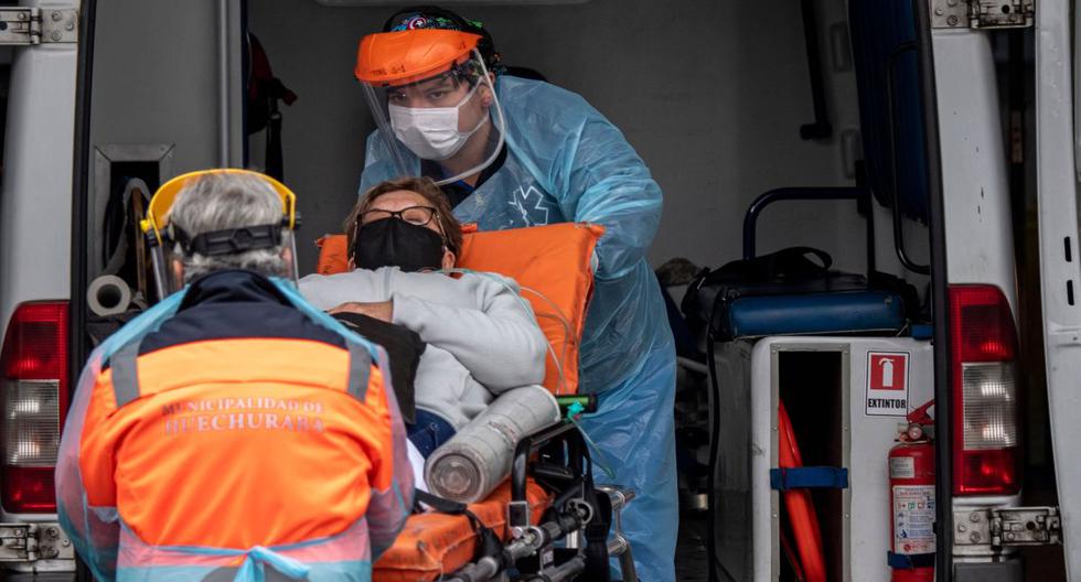 Imagen referencial. Los trabajadores de la salud llevan a un paciente con síntomas del nuevo coronavirus COVID-19 desde una ambulancia a un hospital en Santiago. (AFP / MARTIN BERNETTI).