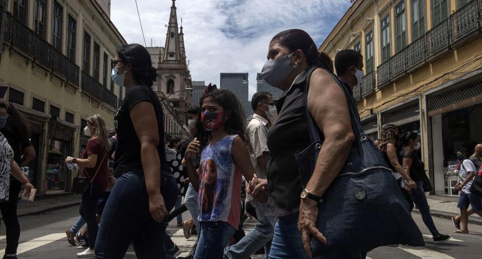 Personas con mascarillas caminan por un paso de peatones en el centro de Río de Janeiro, Brasil, el 8 de diciembre de 2020 en medio de la pandemia del coronavirus. (MAURO PIMENTEL / AFP).