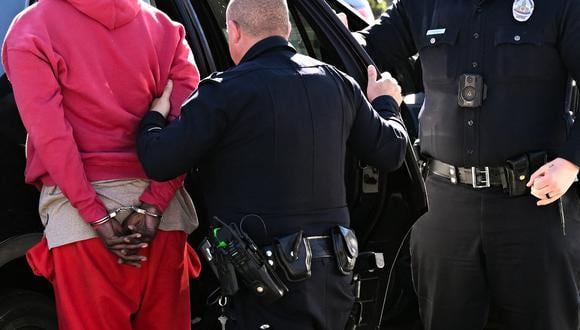 Un oficial del Departamento de Policía de Los Ángeles detiene a un sujeto en Los Ángeles, California el 31 de enero de 2023. ( Foto de Patrick T. Fallon / AFP)
