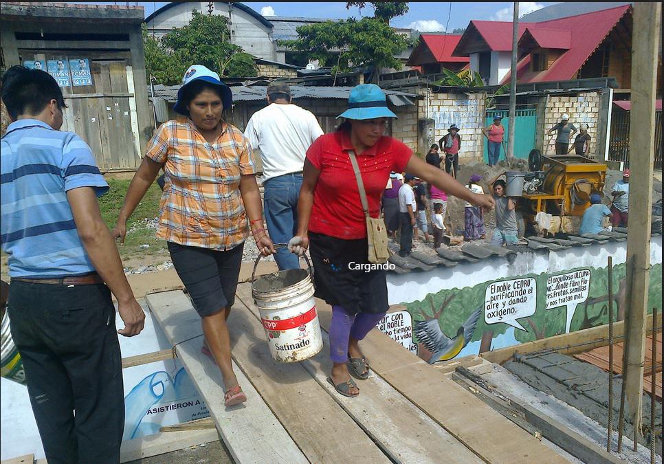 Madres de familia cargan latas de cemento para techar aulas