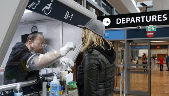 Un médico recolecta una muestra de hisopo de un viajero en un centro de pruebas rápidas de coronavirus COVID-19 en el aeropuerto Ben-Gurion de Israel en Lod, cerca de Tel Aviv, el 19 de enero de 2021. (JACK GUEZ / AFP).
