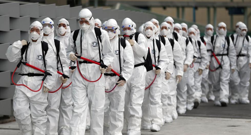 Los soldados surcoreanos que usan equipo de protección se mueven para rociar desinfectante como parte de las medidas preventivas contra la propagación del coronavirus COVID-19. (AFP).