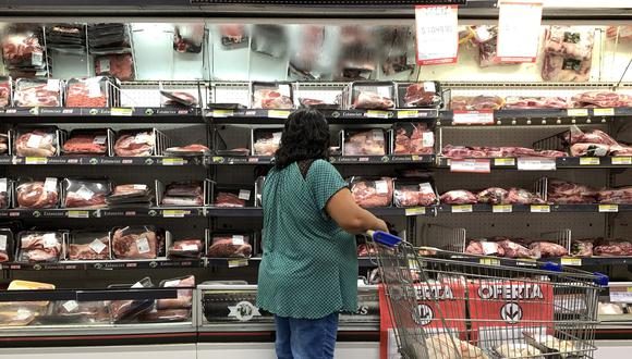A customer looks at the prices of meat cuts at a supermarket in Buenos Aires on February 9, 2023 the day that the "Precios Justos" programme records a rise in prices. - The programme, which regulates prices and was agreed between the Argentine Government and businessmen, is aimed at fighting inflation and at stabilising prices in the short term, so people can regain purchasing power. (Photo by STRINGER / AFP)