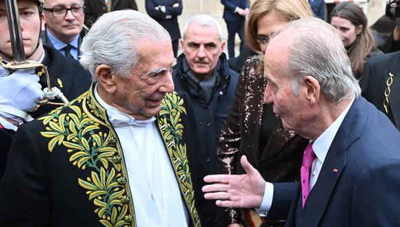 El escritor peruano y premio Nobel de literatura Mario Vargas Llosa (izquierda) habla con el ex rey de España Juan Carlos I (derecha) al final de la ceremonia de la Académie Francaise (Academia Francesa), en París, el 9 de febrero de 2023. (Foto de Emmanuel DUNAND / AFP)