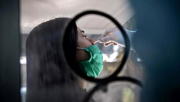 Imagen referencial de una mujer sometiéndose a una prueba PCR. (Foto: AFP)