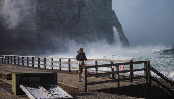 Un peatón observa las altas olas que rompen sobre la playa de Etretat, Normandía, en el oeste de Francia, el 18 de febrero de 2022, cuando la tormenta Eunice golpea la costa de Normandía. (Foto de Sameer Al-DOUMY / AFP)