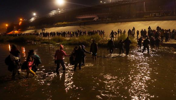 Migrantes que viajan en una caravana, ensu mayoría venezolanos cruzan el río Bravo para pedir asilo político en Estados Unidos, en Ciudad Juárez, estado de Chihuahua, México, el 11 de diciembre de 2022. (Foto de HERIKA MARTINEZ / AFP)