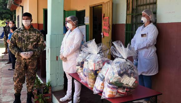 Los trabajadores y el soldado del ejército repartieron bolsas con alimentos como parte de un plan de ayuda del gobierno en Asunción, durante un bloqueo total contra la propagación del nuevo coronavirus. (Foto: AFP/Norberto Duarte)
