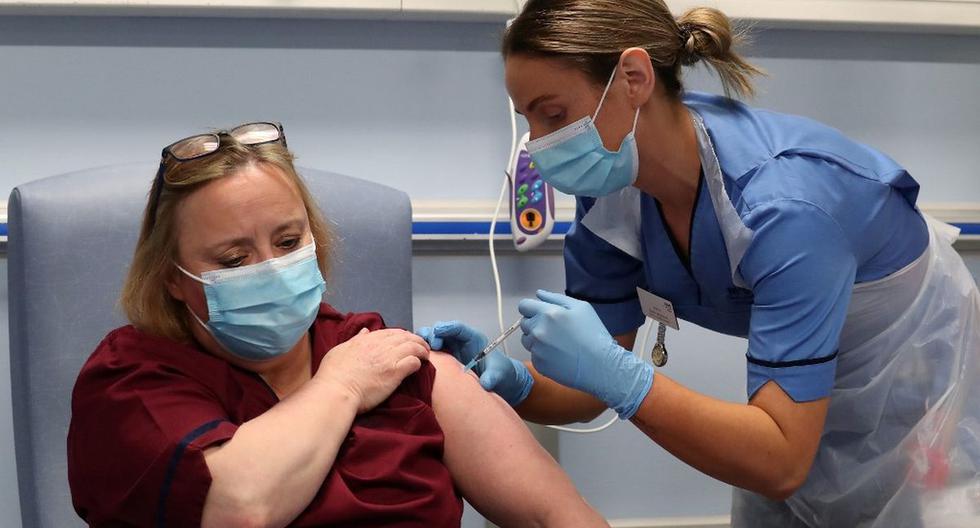 La enfermera a cargo adjunta Katie McIntosh administra la primera de dos inyecciones de vacuna Pfizer / BioNTech Covid-19 a Vivien McKay Clinical Nurse Manager en el Western General Hospital en Edimburgo, Escocia. (Foto de Andrew Milligan/AFP).