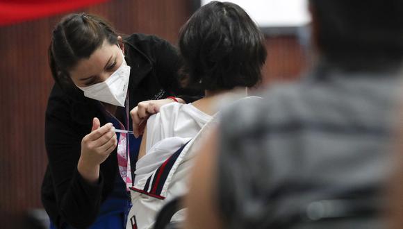 Una mujer recibe una dosis de la vacuna contra el COVID-19 en un centro de vacunación de Santiago. (Foto: JAVIER TORRES / AFP)
