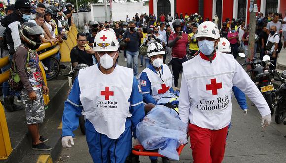 Miembros de la Cruz Roja Colombiana levantan el cuerpo sin vida de un hombre hoy, durante las manifestaciones en el sector La Luna, en Cali, Colombia. (EFE/Ernesto Guzmán Jr)