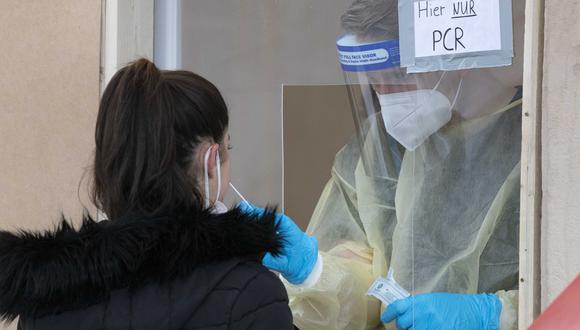 A una mujer se le toma una muestra para una prueba PCR en una estación de prueba en Ludwigsburg, sur de Alemania, el 7 de diciembre de 2021. (Foto de THOMAS KIENZLE / AFP)