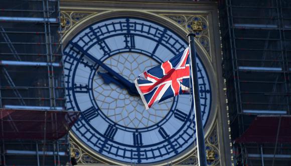 Bandera ondea con la brisa frente a la esfera del reloj de la Torre Elizabeth, conocida por la campana del Big Ben, en el centro de Londres el 30 de diciembre de 2020. (JUSTIN TALLIS / AFP).