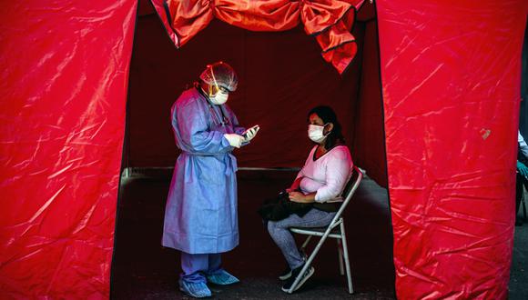 Un trabajador de salud toma un tes de COVID-19 a una persona, en Lima (Foto: ERNESTO BENAVIDES / AFP)