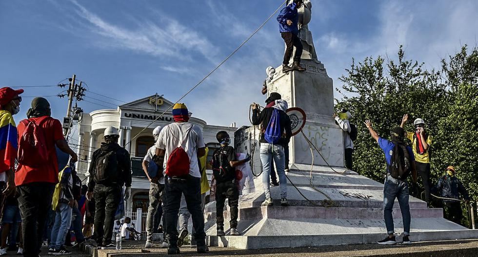 Manifestantes derriban una estatua de Cristóbal Colón durante una manifestación contra el gobierno en Barranquilla, Colombia, el 28 de junio de 2021. (Mery Grandos Herrera / AFP).